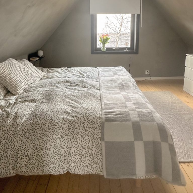 Klein und modernes Schlafzimmer mit zwei Betten, Fenster und minimalistisch skandinavischer Einrichtung.