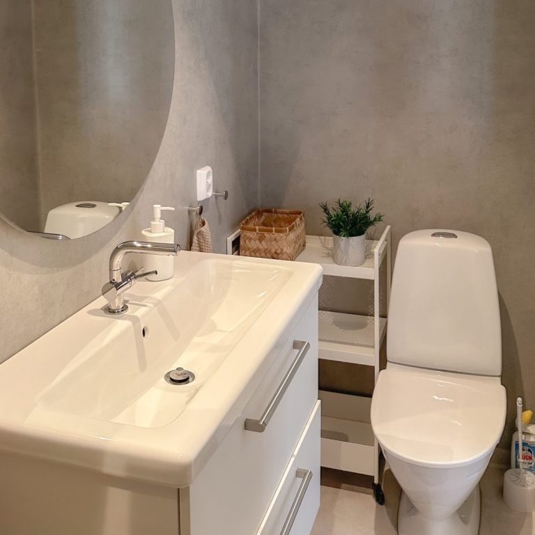 Modernes Badezimmer mit Dusche, Waschtisch und Spiegel in neutralen Farben.